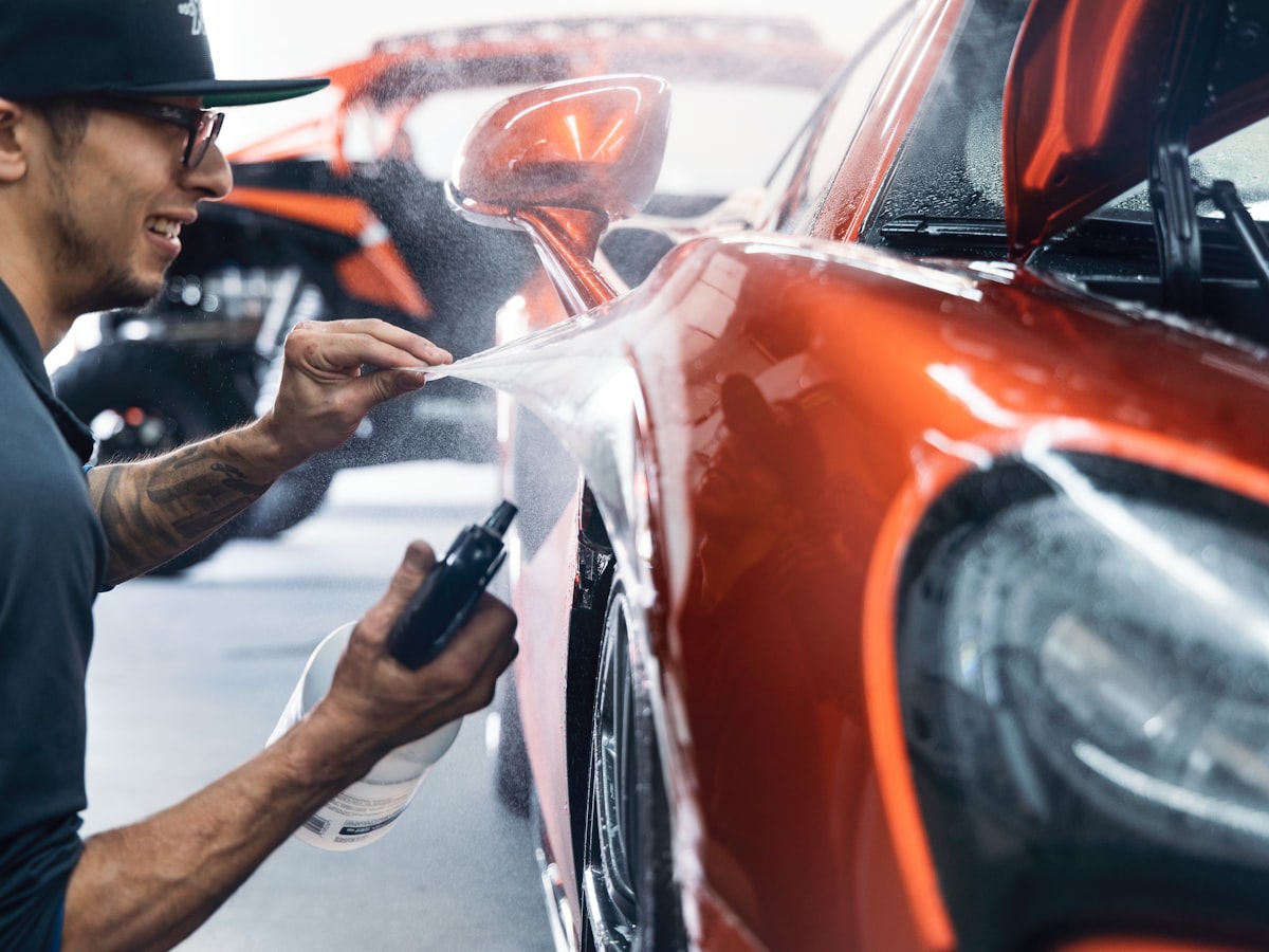 Spray painting a car panel in the body shop